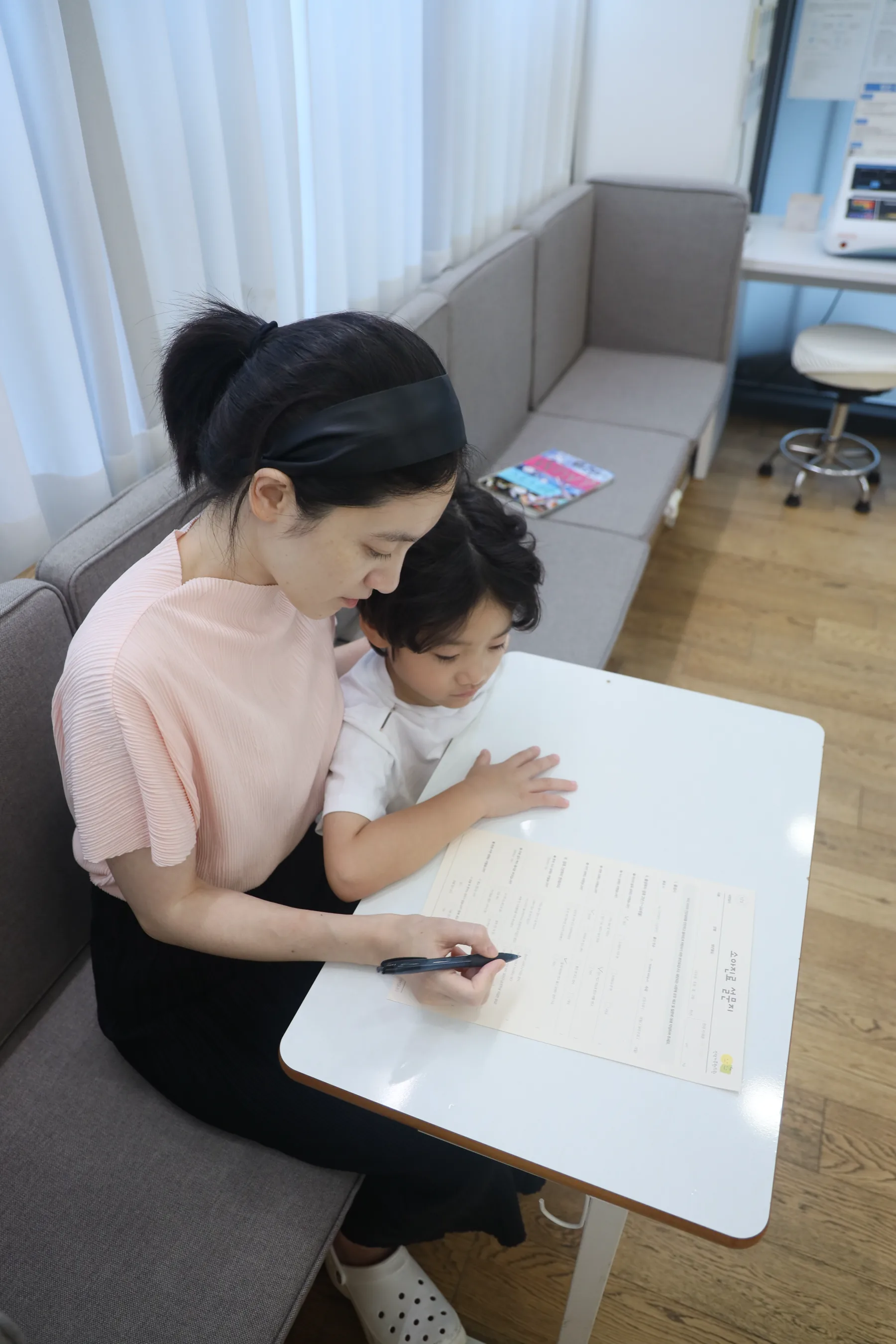인덕가족한의원에서 보호자와 아이가 소화와 식욕 상태 설문지를 작성하는 모습